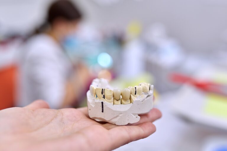 Dentist showing a custom dental crown for a patient at Reston Serenity Smiles in Reston, VA